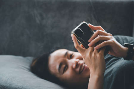 Asian women are happily exercising at her home. While using a smartphone. Technology concepts and daily life.Online social concepts and modern lifestylesの写真素材
