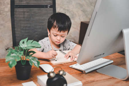 E-learning,Online education, Little asian boy studying homework math during her online lesson at home with computer pc, Social distance, Quarantine,  Online education conceptの写真素材
