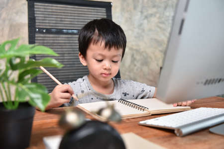 E-learning,Online education, Little asian boy studying homework math during her online lesson at home with computer pc, Social distance, Quarantine,  Online education conceptの写真素材