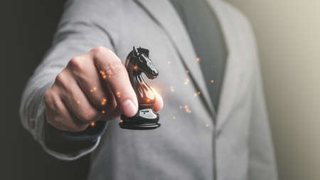 Businessman holding knight chess piece . concept of business strategy and tactic.strategy, management or leadership conceptの写真素材