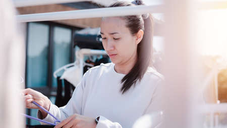 Beautiful asian woman is drying clothes.housewife doing housework concept.life style.の写真素材