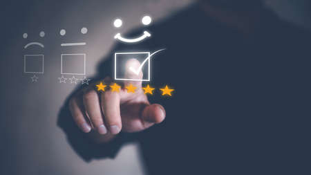 Customer service and Satisfaction concept  ,Business people are touching the virtual screen on the happy Smiley face icon to give satisfaction in service. 5-star rating very impressed.の写真素材