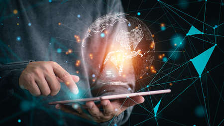 businessman holding digital tablet with Global network connection on screen. Big data analytics and business intelligence concept. World map point and line composition concept of global business.の写真素材