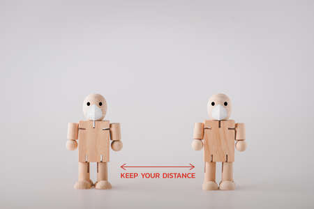 The idea of ââencouraging the use of measures to keep the distance by using a wooden doll as a representative.Social distancing, keep distance in public society people to protect from COVID-19 coronavirus outbreak spreading concept.の写真素材