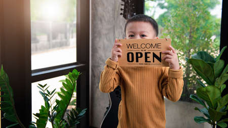 Asian baby boys are very cute handsome and good looking, holding a sign showing the word  Open ....