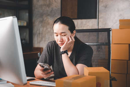 Sell ââonline Concept of doing business at home. Asian beauty Answering to a customer chat with a smartphone to receive product orders. SME or Small medium economy.Online merchant career.の写真素材