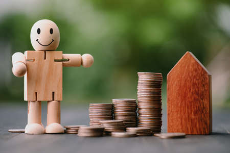 Investment in the real estate business. Money coin stack growing graph and wood house model. Loans for the purchase of residential houses.Save for the future.の写真素材