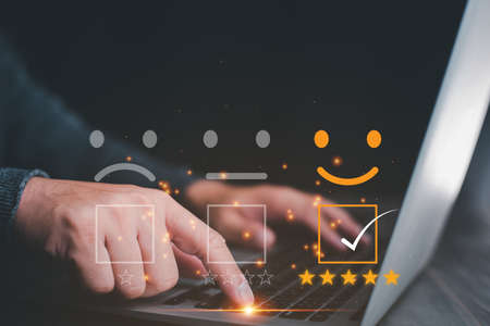 Customer service satisfaction survey concept.Business people or customers show satisfaction through the application on the tablet screen. By giving the most satisfaction rating and 5 stars.の写真素材