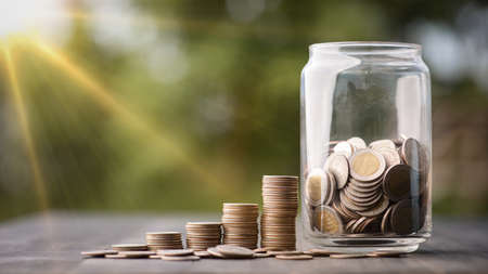 saving money and investment concept. Money coin stack growing graph and coins in jug glass. Balance savings Interest and investment Concept.Business planning and financial management.の写真素材
