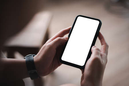 woman's hand holding black mobile phone with blank desktop screen. empty screen for mockup image or advertisement.の写真素材