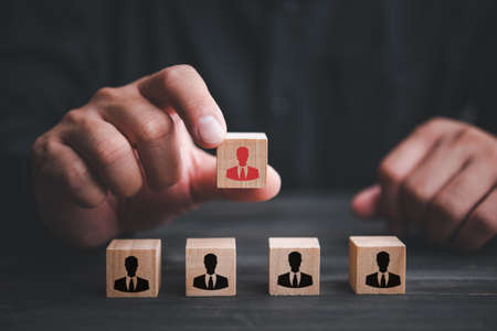 Choice of an employee leader from the crowd. Man holds an employee in hand. Looking for good worker. HR, HRM, HRD concepts. Human resource management.の写真素材