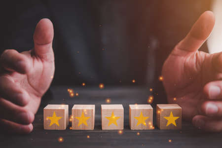 Customer Service satisfaction concept. hand protect the stars to complete five stars. with copy space.giving a five star rating. Maintaining service standards.の写真素材