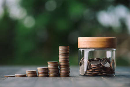 saving money and investment concept. Money coin stack growing graph and coins in jug glass. Balance savings Interest and investment Concept.Business planning and financial management.の写真素材