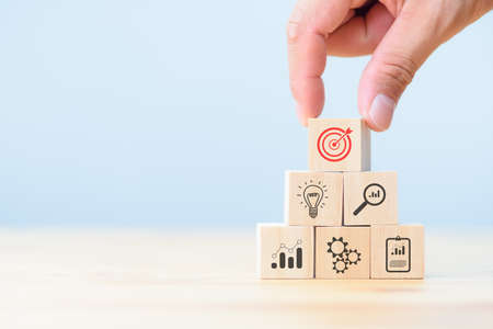 Business development strategy and action plan concept. hand arranging wood block with icon business strategy and Action plan.の写真素材