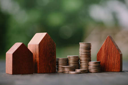 Investment in the real estate business. Money coin stack growing graph and wood house model. Loans for the purchase of residential houses.Save for the future.の写真素材