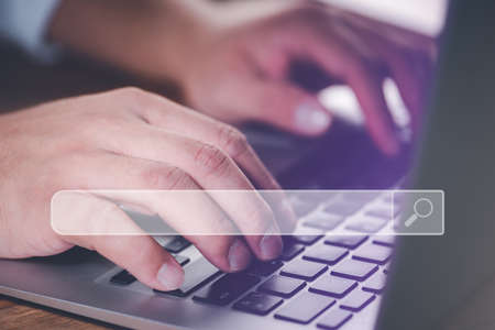 Searching Browsing Internet Data Information with blank search bar.Search Engine Optimization SEO Networking Concept.hand of businessman working with computer laptop on desk in office.の写真素材