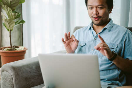 business man making face time video calling teleconference. using application for meeting online via laptop computer at home office. tutor giving online class E-learning concept.の写真素材