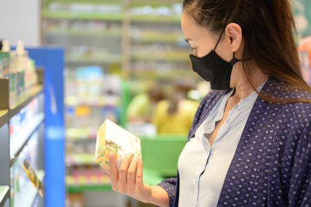 Shopping in the supermarket. Asia Woman checking food labelling.の写真素材