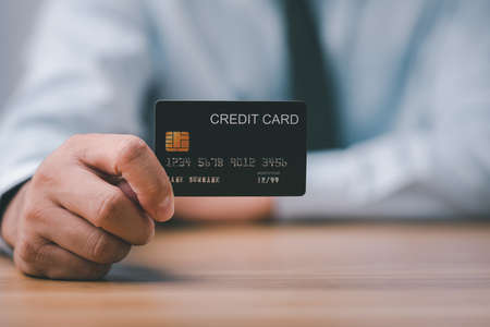 businessman hand holding and showing mockup credit card on desk office.の写真素材