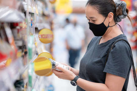 Shopping in the supermarket. Asia Woman checking food labelling.の写真素材