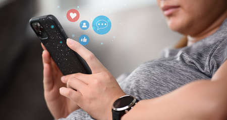 Person using a social media marketing concept on mobile phone with notification icons. Concept of using a smartphone for social mediaの写真素材