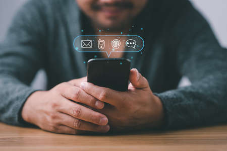 Customer support hotline Contact us people connection. Businessman using Smart Phone with the email, call phone, address, Chat message icons.の写真素材