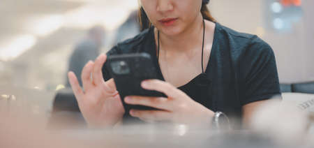 Closeup image of a young smart asian female holding and using smart phone.の写真素材