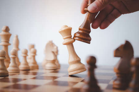 male hand moving chess piece on chess board game concept for ideas and competition and strategy, business success concept, business competition planing teamwork strategic concept.の写真素材