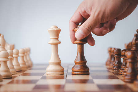 male hand moving chess piece on chess board game concept for ideas and competition and strategy, business success concept, business competition planing teamwork strategic concept.の写真素材