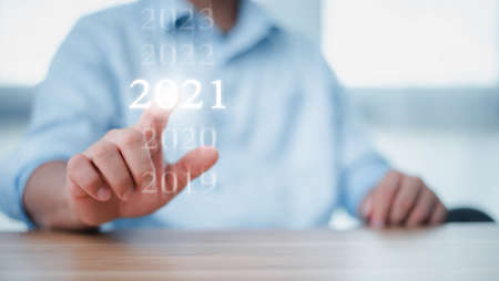 New year 2020 change to 2021 concept, hand touching on 2021 virtual screen. new years business.の写真素材