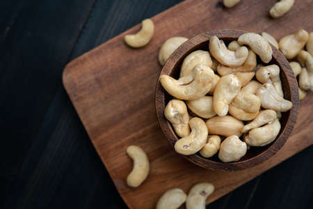 raw cashew nuts in wooden bowl on rustic table, healthy vegetarian snackの写真素材