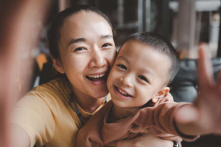 Asian beautiful Mother and child happily beautiful young mom and cute little boy are sitting...