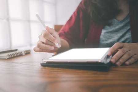 hand of woman copywriter working freelance project in modern cafe. Businesswoman using smartphone and tablet, searching information on website. Successful business. Online training courses conceptの写真素材