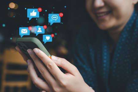 Social media and digital online concept, woman using smart phone on sofa at home. The concept of living on vacation and playing social media.の写真素材