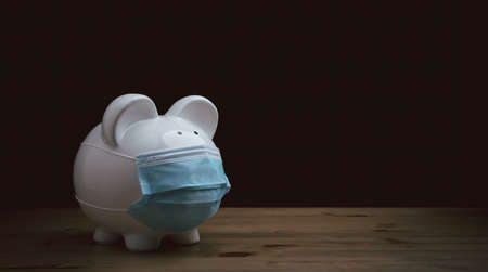 Piggy bank wearing surgical face mask. Global economy during coronavirus pandemic.  Financial crisis, banking concept. saving and investment.の写真素材