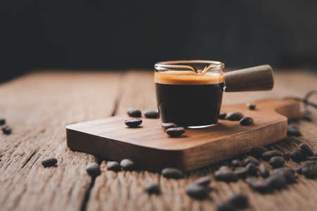 espresso coffee in cup and coffee beans on old wood table. espresso shot.の写真素材