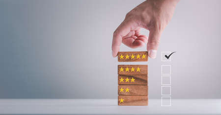 feedback rating and positive customer review experience, service and Satisfaction, Business people are Choosing wood block with 5 star icon to give satisfaction in service. rating very impressed.の写真素材