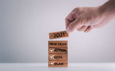 2021 New year resolution, Goal, Plan and action, human hand putting wood block with word.の写真素材