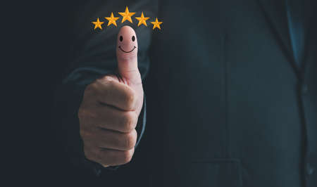 Customer service satisfaction survey concept.Business people or customers are thumbs up to show their satisfaction in service.Men give a 5 star satisfaction rating.の写真素材
