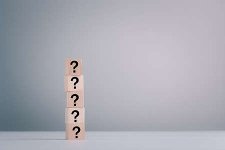 Cubes wooden with question marks icon on gray background, closeup. copy Space for text