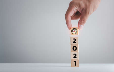 New year 2021 and goal target plan, Hand holding wood cubes with New year 2021 and goal or target icon. concept of New year Business goals and vision.の写真素材