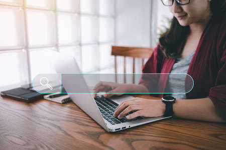 Searching Browsing Internet Data Information with blank search bar.Search Engine Optimization SEO Networking Concept.hand of woman working with computer laptop on desk in office.の写真素材