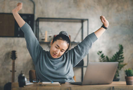 Young Asian Business woman stretching herself and exercise for relaxation while working at home office.の写真素材