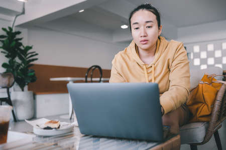Young Asian Woman Working On Laptop In Cafeの写真素材