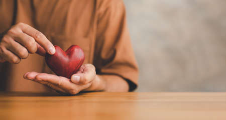 Male hands holding red heart, world mental health day and world heart day, Life and health insurance, CSR social responsibility, organ donation, âconcept of loveの写真素材