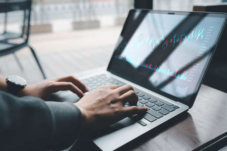 planning and strategy, Stock market, Hands of business people working at modern cafe. Technical price graph and indicator, red and green candlestick chart and stock trading computer screen background.の写真素材