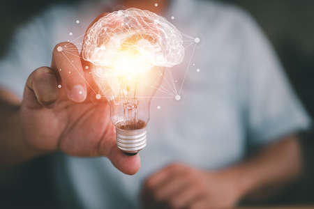 Idea concept and light bulbs with Brain and connection line, businessman show new ideas with innovative technology and creativity.の写真素材