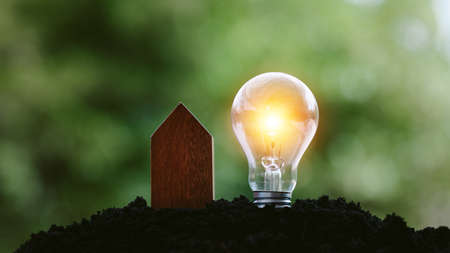 Eco house concept, Small model of home and lightbulb over soil.House Energy Saving Conceptの写真素材