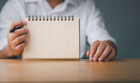 Businessman showing note book with copy space with pen. To do list template. Goals or business...