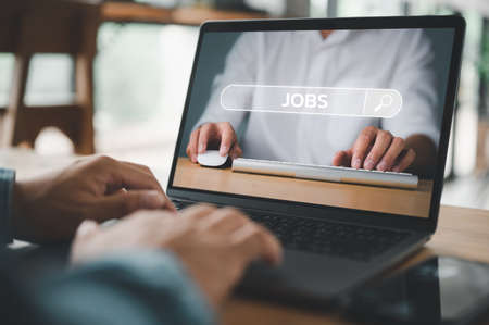 job search concept, man browsing work opportunities online using job search computer app. find your career, man looking at online website by laptop computer.の写真素材